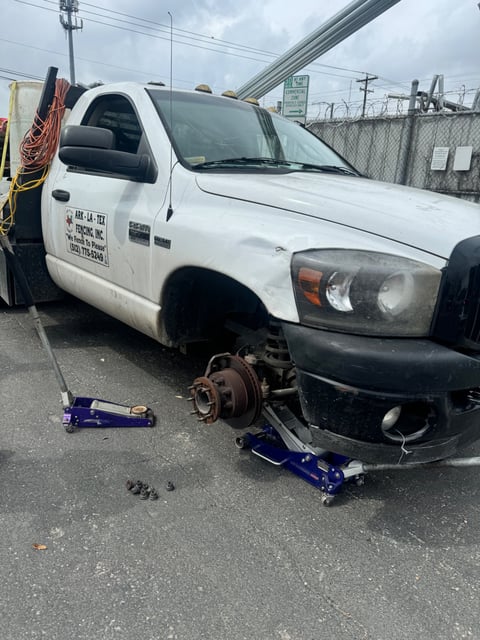 Dodge Ram pickup raised on dual jack stands with both front wheels off for tire service by All Hours Roadside in Austin TX