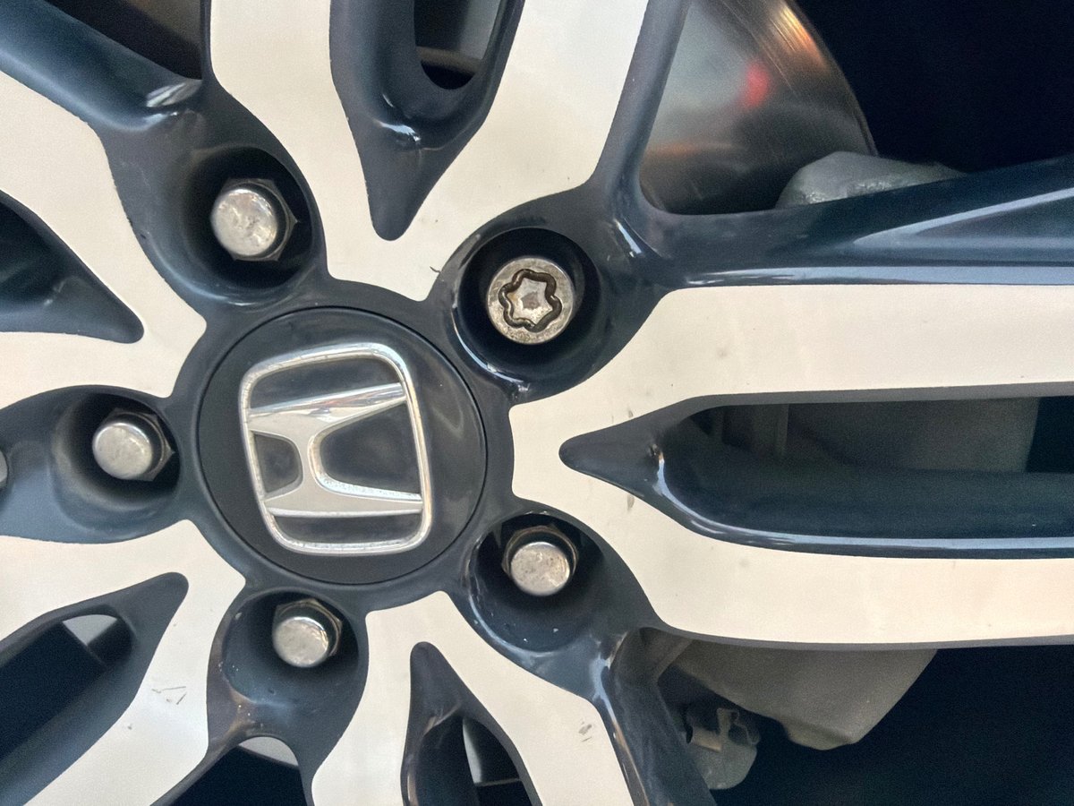7-point star (spline) wheel lock on a black and machined Honda Civic alloy wheel — extracted damage-free with a master removal socket by All Hours Roadside in the Dallas–Fort Worth metro