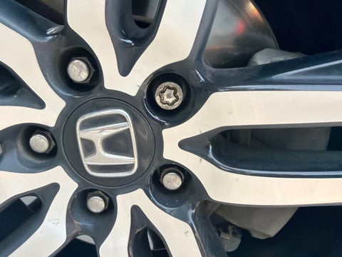 7-point star (spline) wheel lock on a black and machined Honda Civic alloy wheel — extracted damage-free with a master removal socket by All Hours Roadside in the Dallas–Fort Worth metro