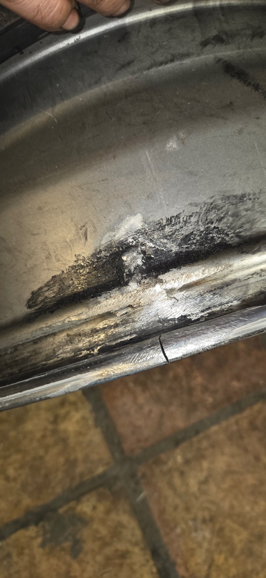 Split aluminum alloy rim with visible crack and prep grinding for TIG weld repair — All Hours Roadside partner shop, DFW