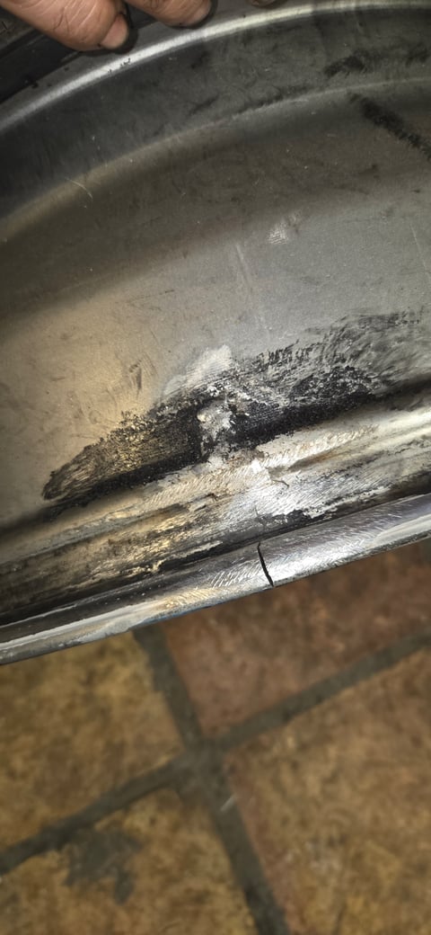 Split aluminum alloy rim with visible crack and prep grinding for TIG weld repair — All Hours Roadside partner shop, DFW