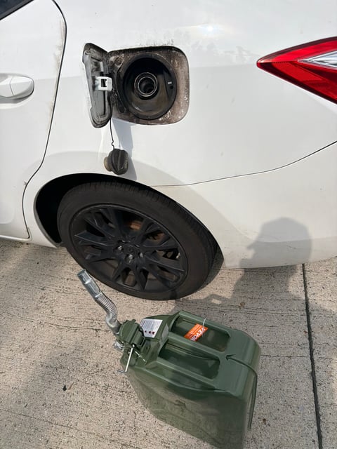 Out-of-gas Toyota Corolla being refueled roadside in Mansfield TX with a 5-gallon VEVOR fuel can — All Hours Roadside emergency fuel delivery