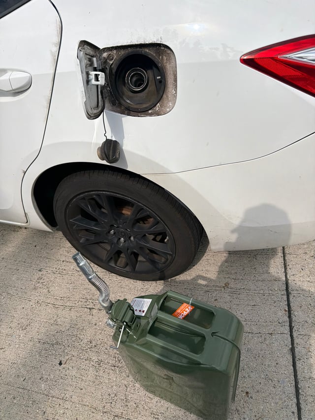 Out-of-gas Toyota Corolla being refueled roadside in Mansfield TX with a 5-gallon VEVOR fuel can — All Hours Roadside emergency fuel delivery