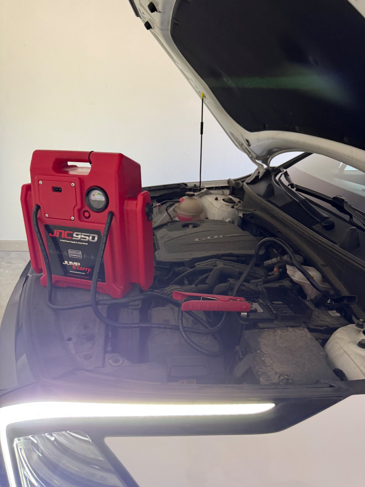 All Hours Roadside technician jump starting a dead car battery in Garland, TX with a JNC950 Jump-N-Carry 12V power supply — flat-rate mobile service near I-635 and President George Bush Turnpike.
