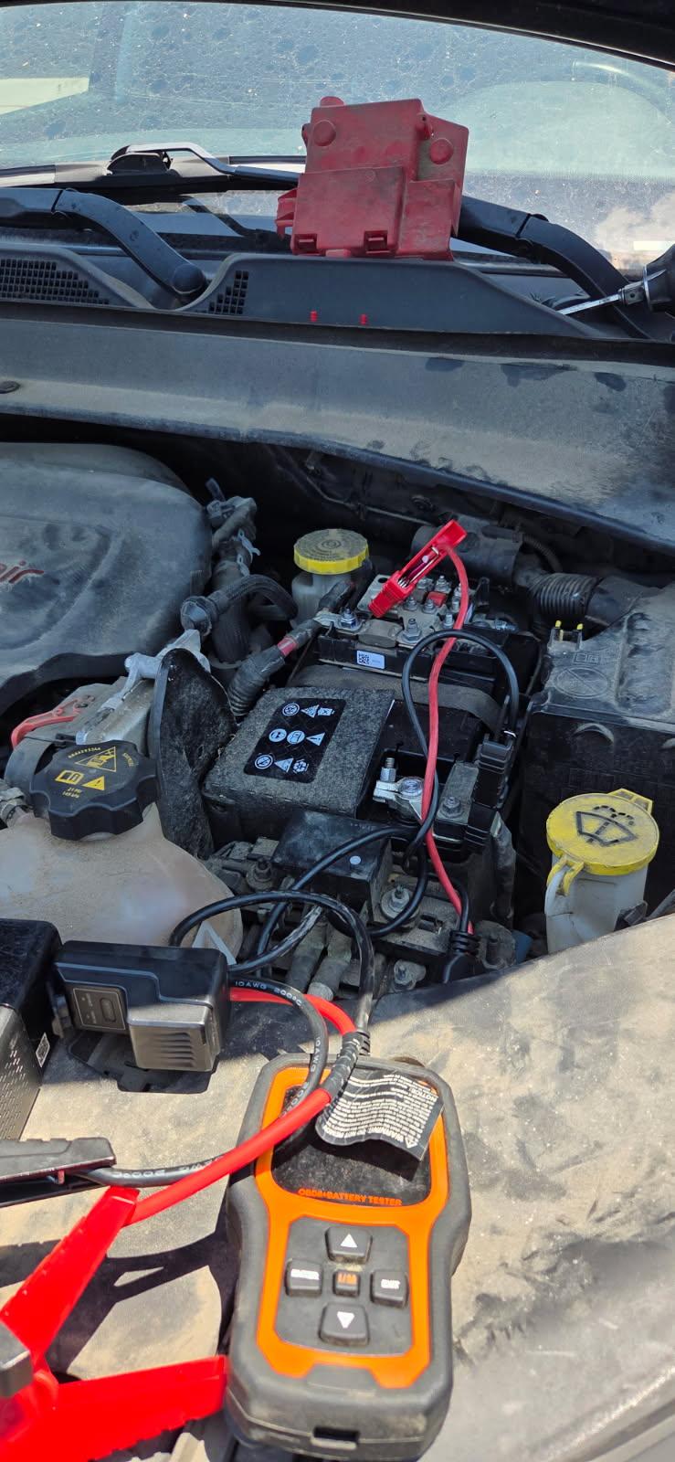 ANCEL AD410 Pro OBDII + battery tester clamped to a sedan OEM battery in Dallas with 10AWG leads and red engineering clamps — All Hours Roadside on-site battery diagnostics